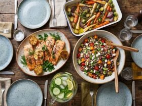 healthy dinner ideas for family , colorful spread of salmon, roasted vegetables, grain salad and water on a wooden family dinner table