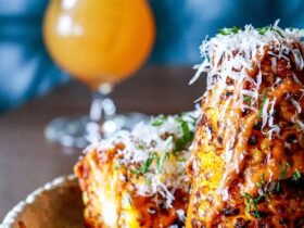 Charred Mexican street corn recipe served on the cob with grated cotija cheese, chile powder and chopped cilantro