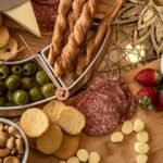Costco charcuterie board style spread with salami, cheese, olives, nuts, strawberries and crackers on a wooden table