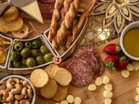 Costco charcuterie board style spread with salami, cheese, olives, nuts, strawberries and crackers on a wooden table