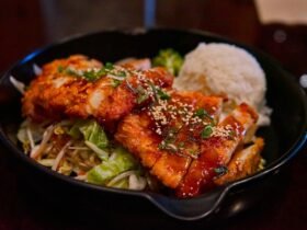Post workout meal ideas: plate of glazed chicken with white rice and greens in a cast iron skillet