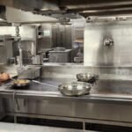 Chef working the line in a licensed commercial kitchen, the kind of space a commissary kitchen rents out