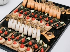 Cocktail party food ideas on one tray: canapes, pinwheels and topped crackers lined up for a standing crowd