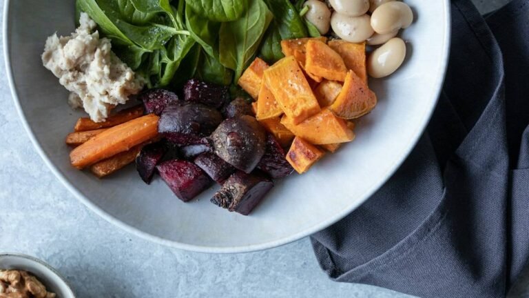 Fall salads in one bowl: spinach, roasted sweet potato, beets, carrots and white beans with walnuts on the side