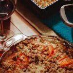 Thanksgiving vegetable side dishes on the table: sweet potato casserole with pecan crumble beside a pot of broccoli