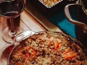 Thanksgiving vegetable side dishes on the table: sweet potato casserole with pecan crumble beside a pot of broccoli