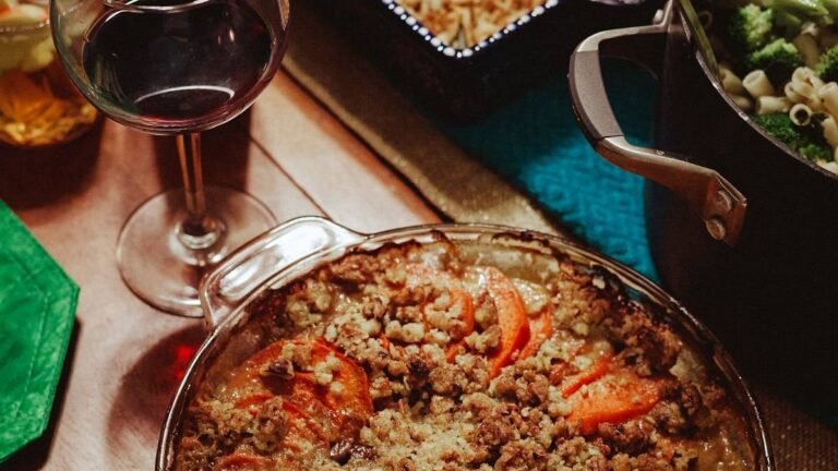 Thanksgiving vegetable side dishes on the table: sweet potato casserole with pecan crumble beside a pot of broccoli