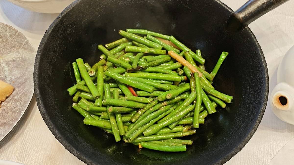 Din Tai Fung green beans recipe result: bright green garlic green beans tossed in a black wok