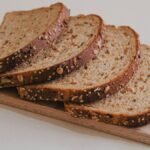 Outback Steakhouse bread recipe inspiration: slices of dark brown whole wheat bread fanned out on a wooden board