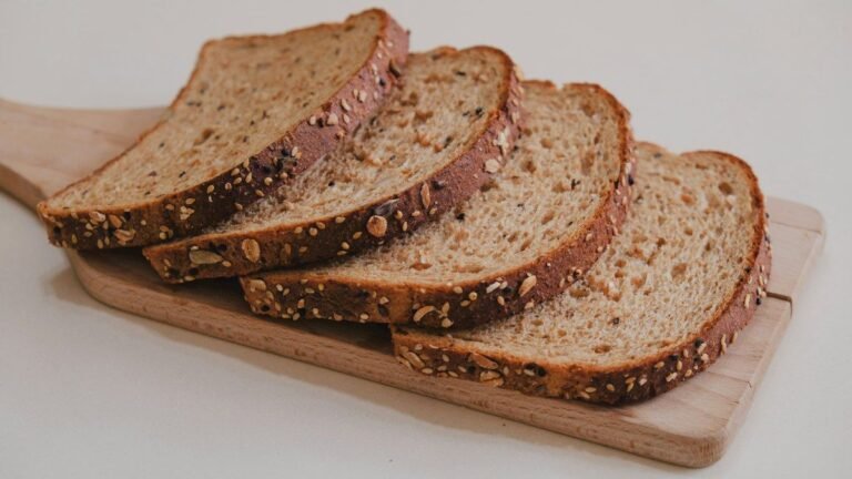 Outback Steakhouse bread recipe inspiration: slices of dark brown whole wheat bread fanned out on a wooden board