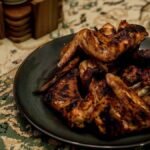 Wingstop Louisiana rub recipe inspiration: crisp seasoned chicken wings piled on a dark plate