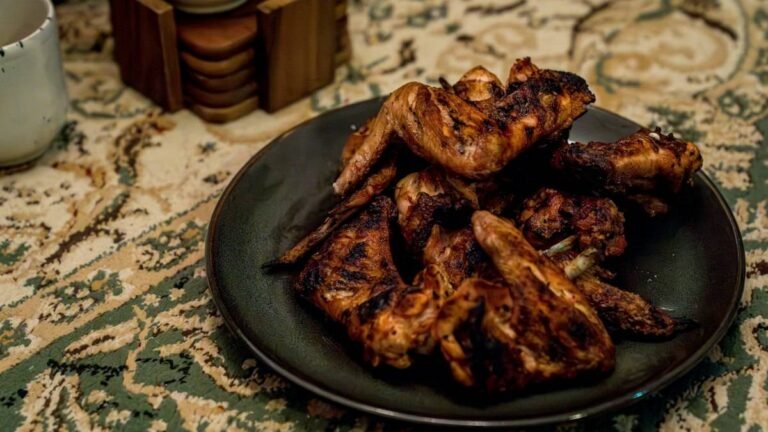 Wingstop Louisiana rub recipe inspiration: crisp seasoned chicken wings piled on a dark plate
