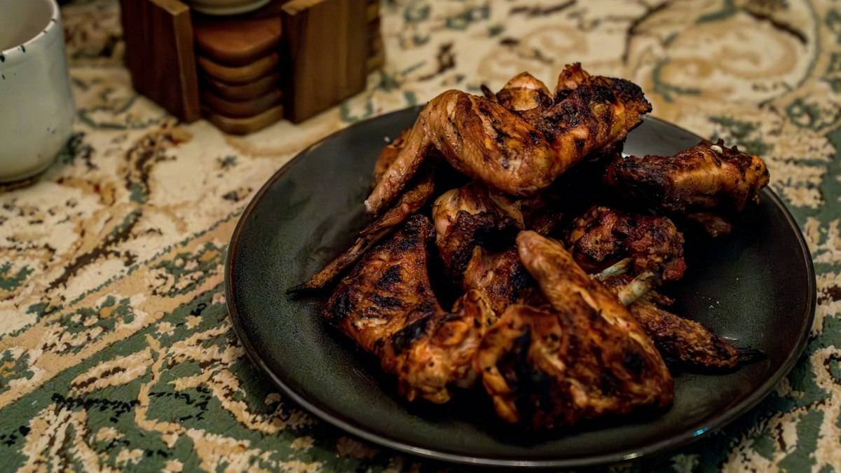 Wingstop Louisiana rub recipe inspiration: crisp seasoned chicken wings piled on a dark plate